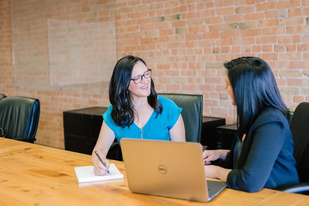 Couple sitting together, examining various financial documents, while a professional advisor points at a pie chart on a screen, indicating financial strategies